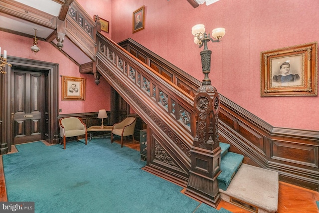 unfurnished room featuring crown molding, carpet flooring, and a high ceiling