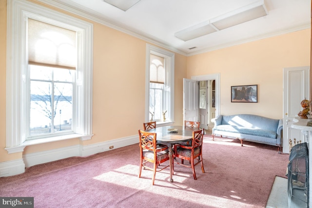 dining area with crown molding, carpet, and a healthy amount of sunlight