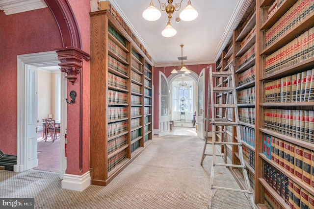 corridor with an inviting chandelier, carpet flooring, and crown molding