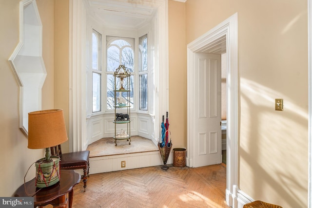 sitting room featuring ornamental molding and light parquet flooring