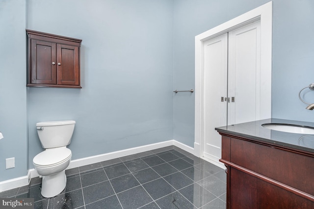 bathroom with tile patterned flooring, vanity, and toilet