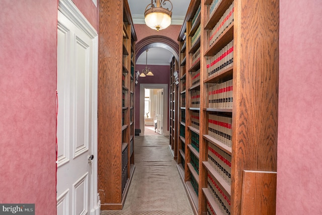 hallway with crown molding and carpet