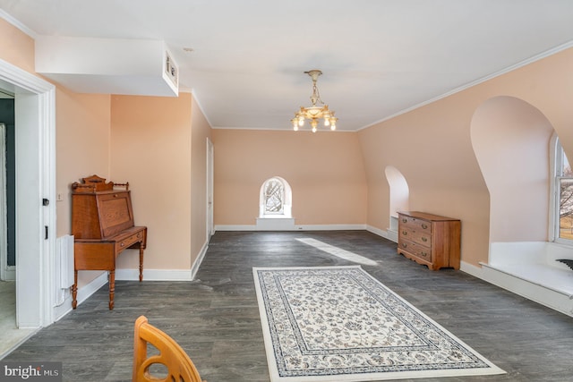 foyer with dark wood-type flooring, crown molding, and a chandelier