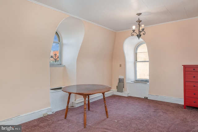 carpeted dining space featuring crown molding and a chandelier