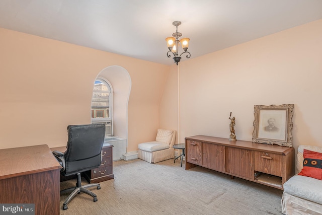 carpeted home office featuring a chandelier