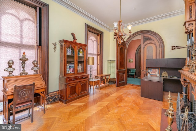 interior space with light parquet flooring, ornamental molding, and an inviting chandelier