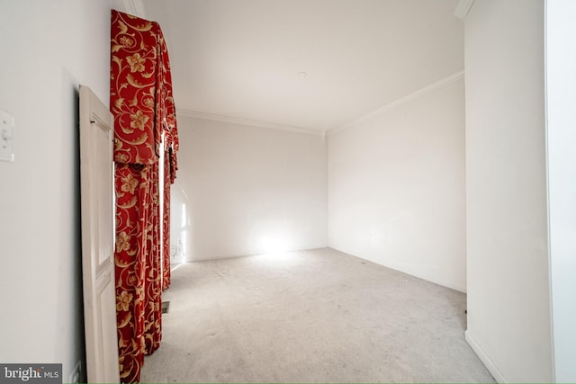 empty room with ornamental molding and light carpet