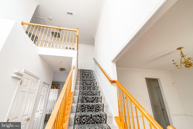 staircase with a high ceiling and ornamental molding