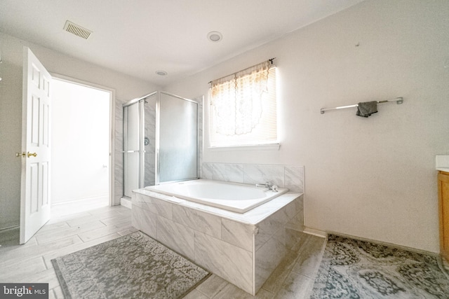 bathroom featuring shower with separate bathtub