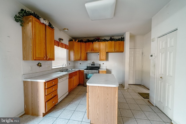 kitchen with sink, gas range, a center island, dishwasher, and backsplash