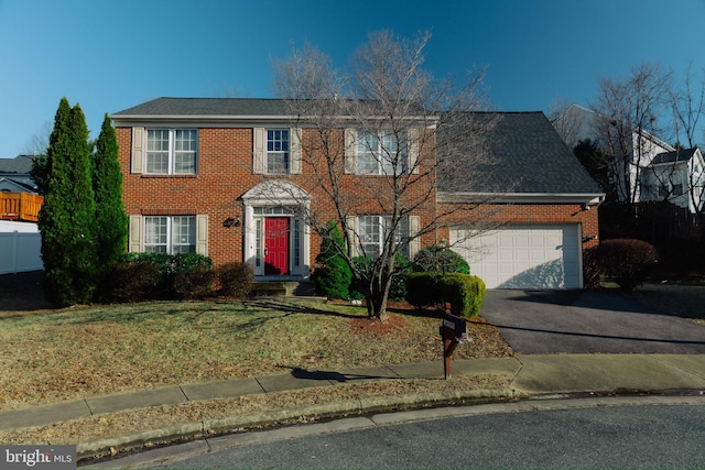 colonial-style house with a garage and a front yard