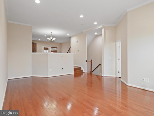 unfurnished room with a notable chandelier, crown molding, and light wood-type flooring