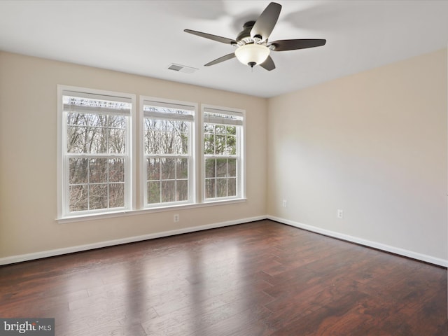 spare room with dark wood-type flooring and ceiling fan