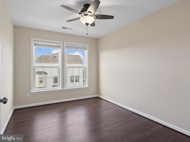 spare room with dark wood-type flooring and ceiling fan