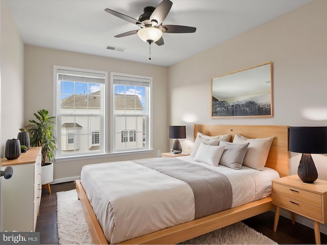 bedroom with dark hardwood / wood-style floors and ceiling fan