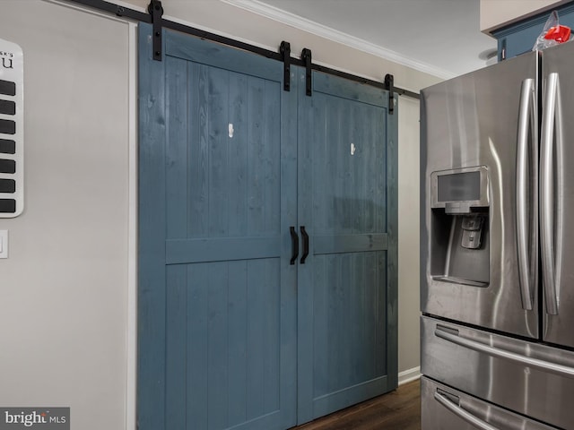 kitchen with stainless steel refrigerator with ice dispenser, a barn door, ornamental molding, and dark hardwood / wood-style flooring