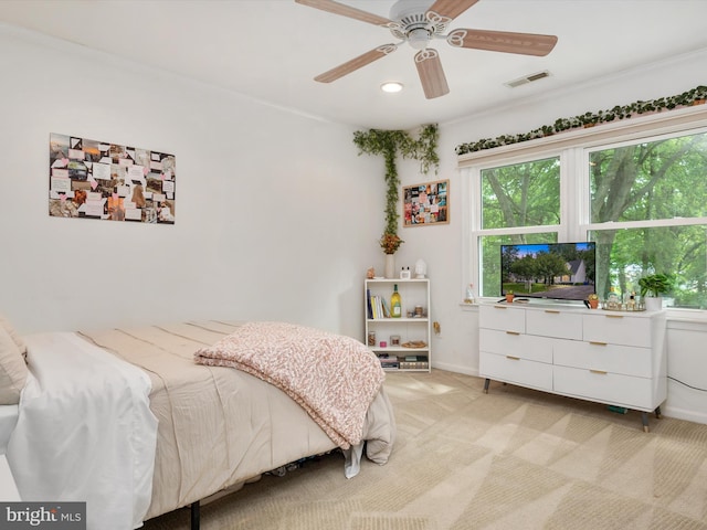 bedroom with multiple windows, light colored carpet, and ceiling fan