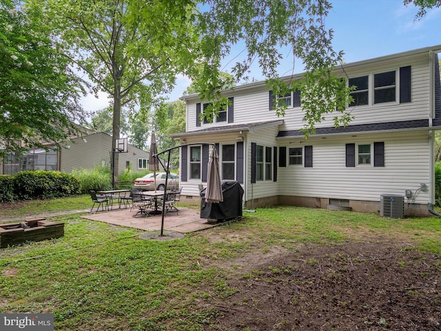 back of house featuring central AC unit, a patio area, and a lawn