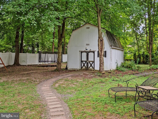 view of yard with a trampoline and a shed