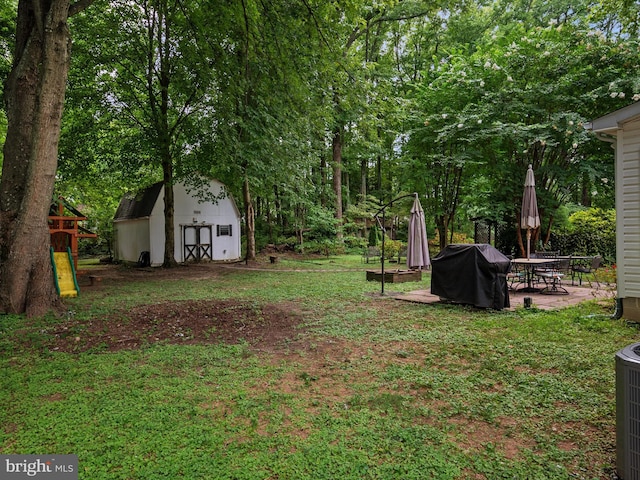 view of yard with a storage shed and a patio