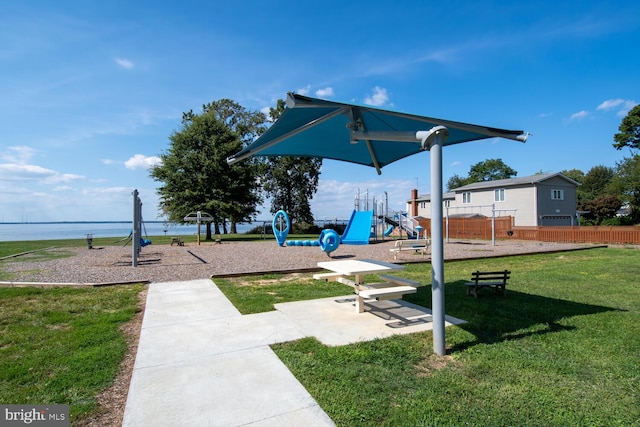 view of jungle gym with a lawn and a water view