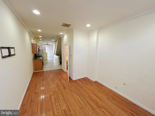 hall with crown molding and light hardwood / wood-style floors