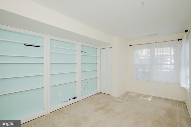 carpeted spare room featuring baseboards