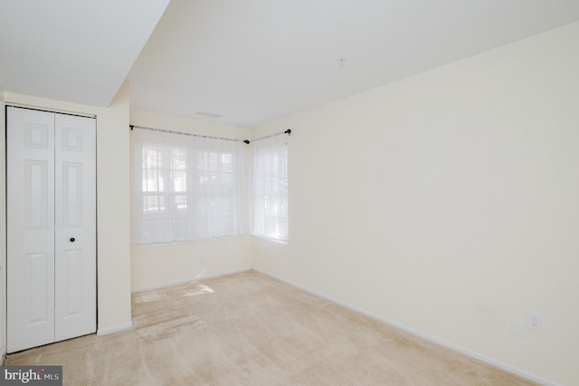 unfurnished bedroom featuring carpet floors, a closet, and baseboards