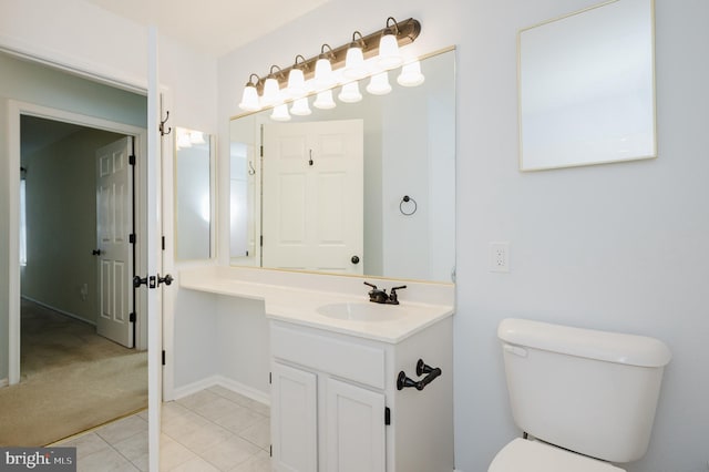 bathroom with toilet, tile patterned floors, and vanity