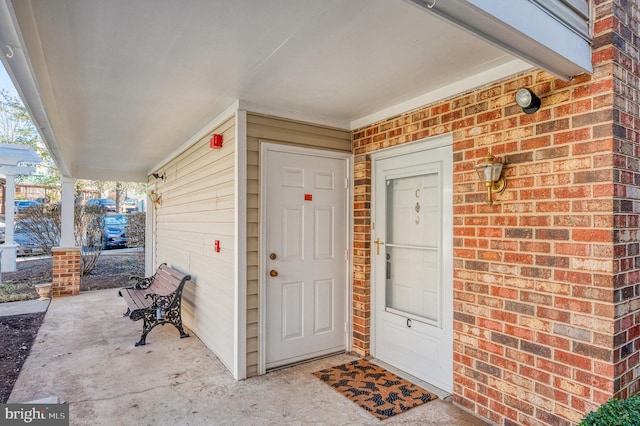 doorway to property with brick siding