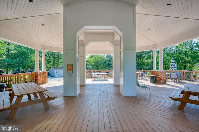 view of patio / terrace with a storage shed, a deck, outdoor dining area, and an outdoor structure