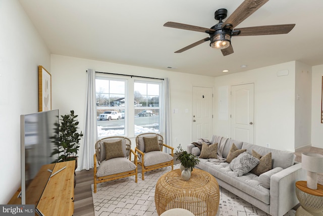 living room with light hardwood / wood-style flooring and ceiling fan