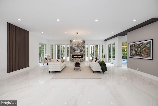 living room with a premium fireplace and a notable chandelier