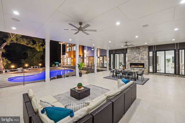 interior space featuring ceiling fan and an outdoor living space with a fireplace