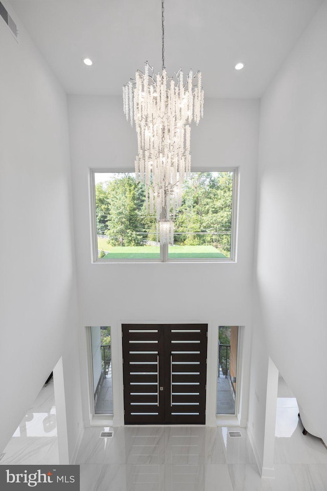 entrance foyer featuring a towering ceiling and an inviting chandelier