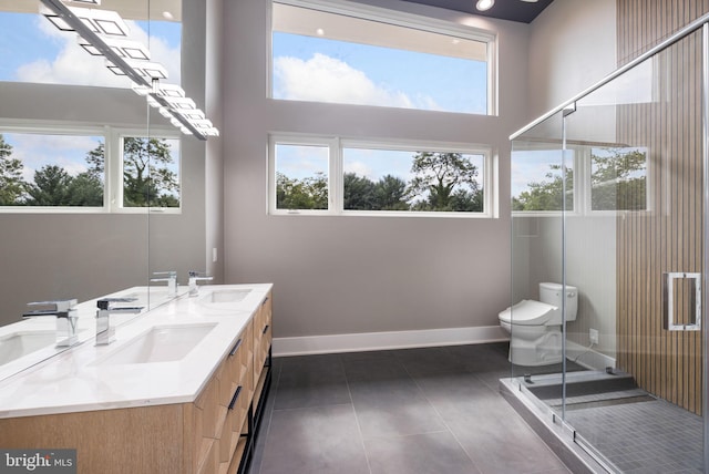 bathroom featuring vanity, tile patterned floors, toilet, and walk in shower