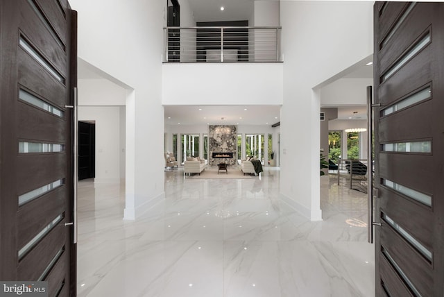 entryway with a towering ceiling and a fireplace