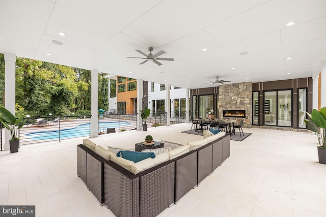 exterior space featuring ceiling fan and an outdoor living space with a fireplace