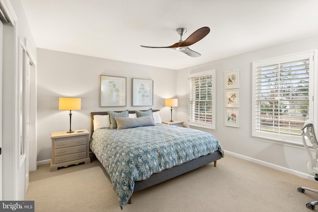 bedroom featuring baseboards, multiple windows, and light carpet