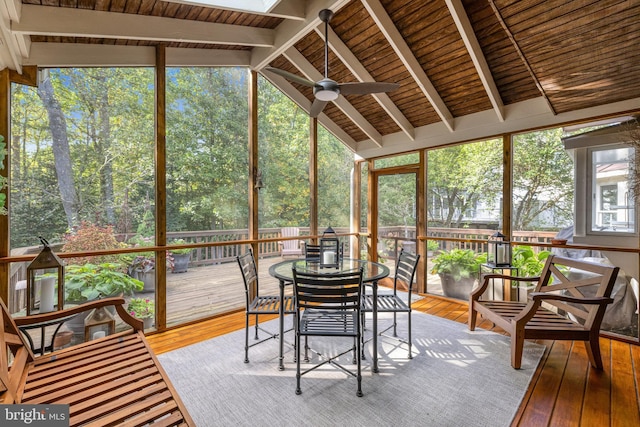 sunroom / solarium with ceiling fan and vaulted ceiling with beams