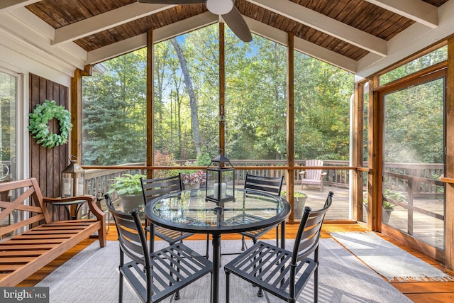 sunroom / solarium with vaulted ceiling with beams, wood ceiling, and a ceiling fan