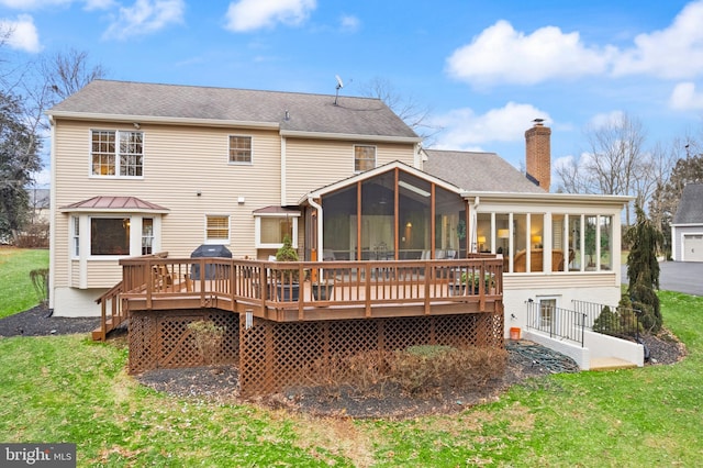 back of house with a yard, a chimney, a sunroom, and a deck