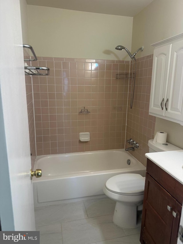 full bathroom featuring tiled shower / bath, vanity, toilet, and tile patterned floors