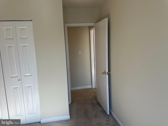 hall with dark colored carpet