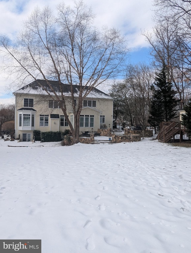 view of snow covered rear of property