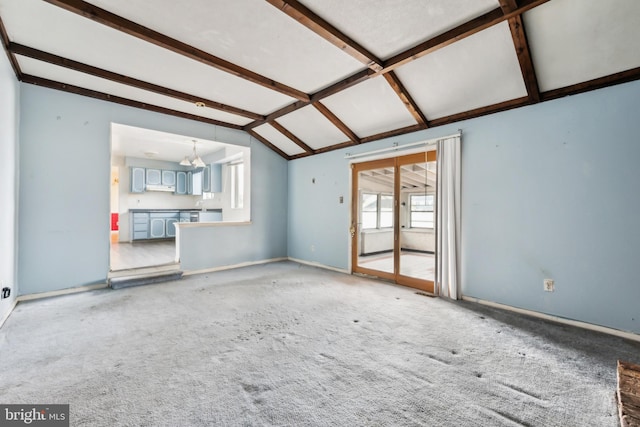 unfurnished living room featuring an inviting chandelier, light carpet, and vaulted ceiling with beams