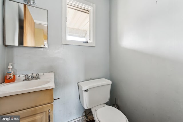 bathroom featuring vanity, a baseboard heating unit, and toilet