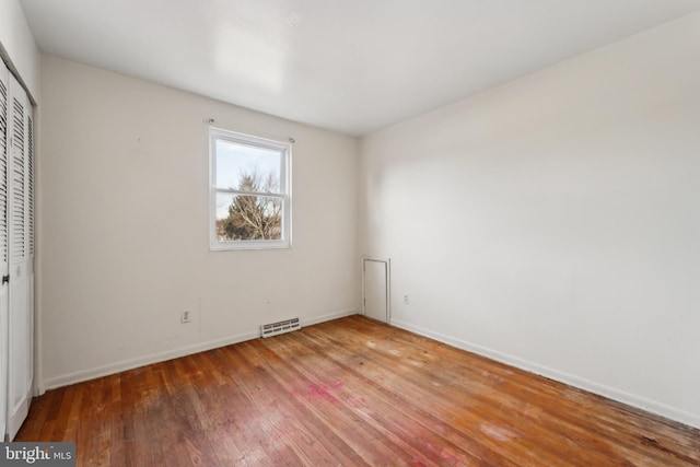 unfurnished bedroom featuring hardwood / wood-style flooring and a closet