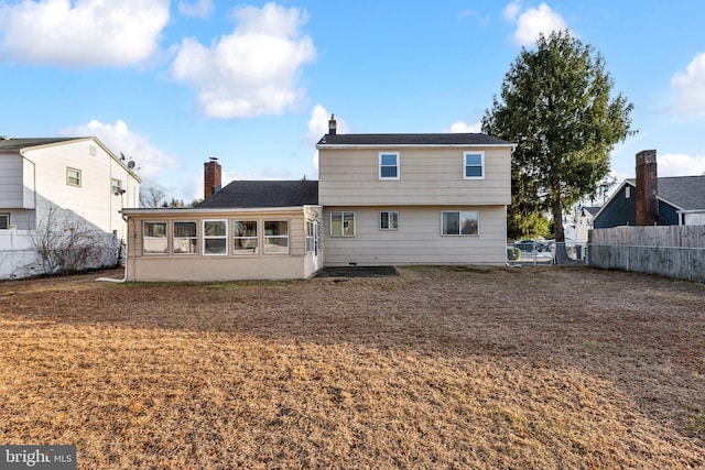 rear view of house featuring a yard