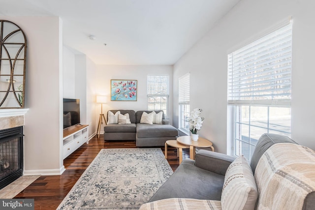 living room featuring dark wood-type flooring and a tile fireplace